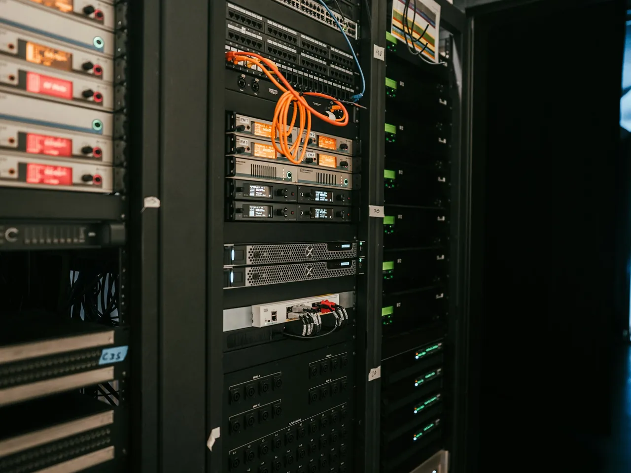 Racks of server and network equipment with orange patch cables
