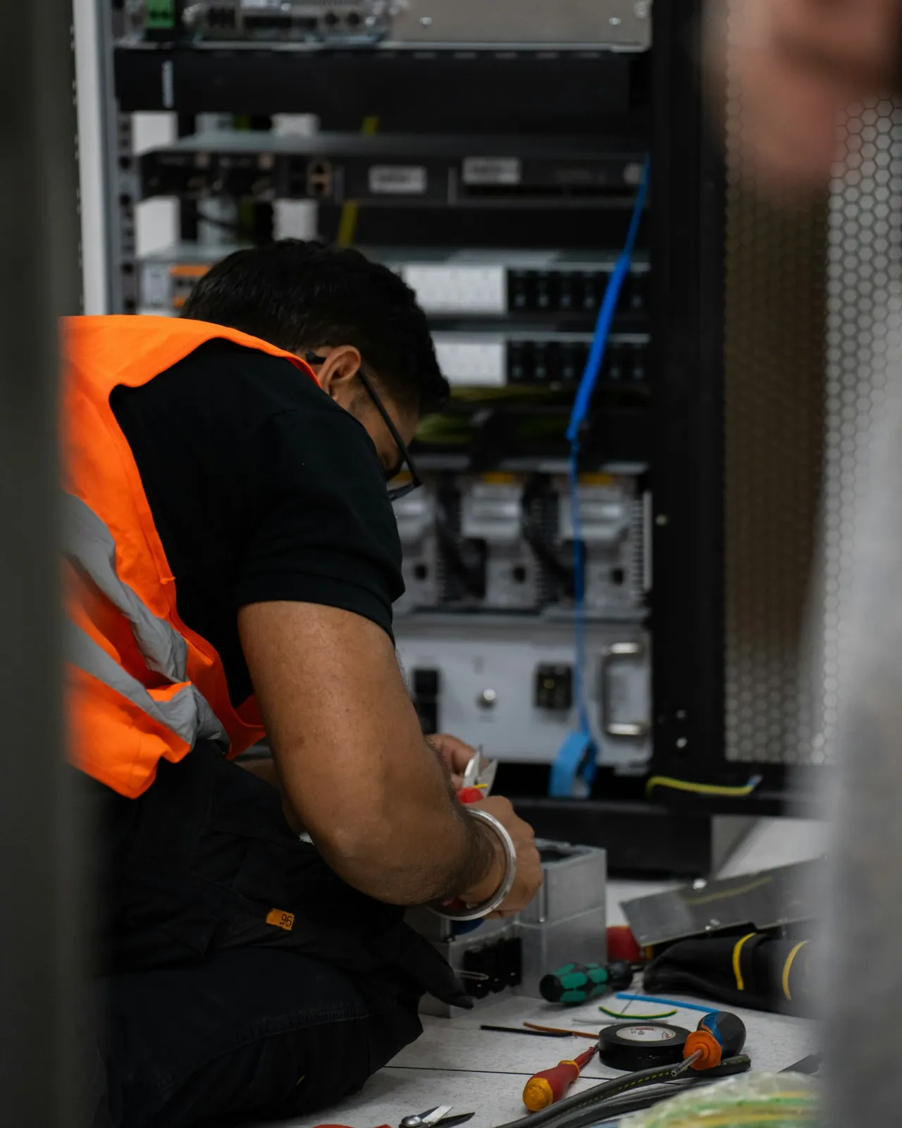 A technician working on rack-mounted server equipment